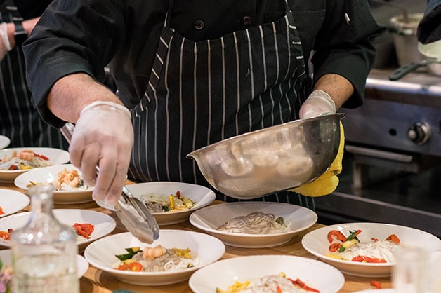 Image of a chef dishing food using tongs
