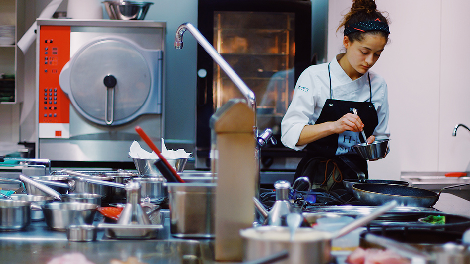An image of a woman working in the kitchen